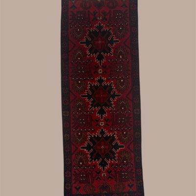 Deep burgundy and black runner featuring repeating geometric medallions and small red and blue accents for a rich, dramatic look.