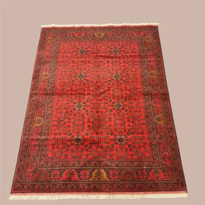 Rich red traditional area rug featuring a dense all-over pattern with dark blue and black detailing and an ornate coordinating border.