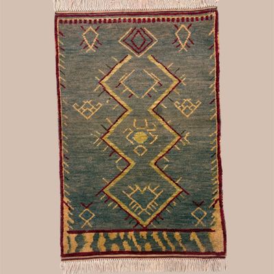 Teal and muted green geometric rug featuring bold angular diamond motifs with warm gold and rust accents for a distinctive...
