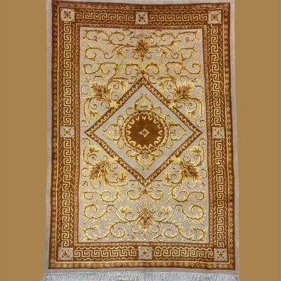 Ivory and gold traditional rug featuring a diamond-shaped central medallion surrounded by delicate scrolling floral details and an ornate...