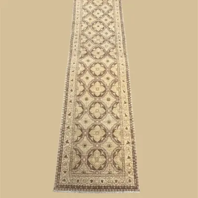 Neutral ivory runner featuring repeating geometric medallions with subtle gold and brown accents. An elegant option for a hallway or...