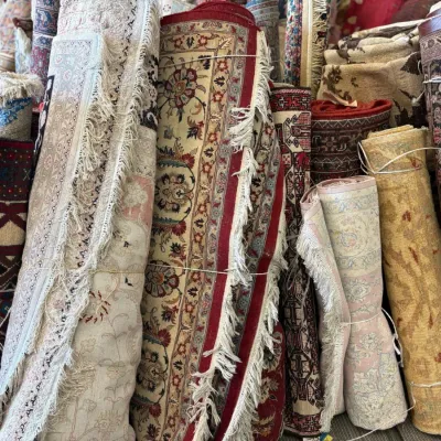 Large assortment of rolled handmade rugs featuring traditional florals, medallions, geometric patterns, and neutral designs.