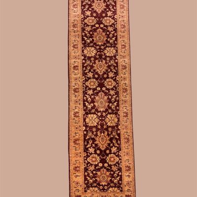 Narrow blue and rust runner featuring repeating floral medallions and an ornate border. Ideal for a hallway or narrow entry.
