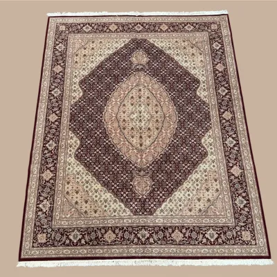 Soft ivory and mauve traditional rug featuring a large diamond-shaped central medallion and detailed ornamental border.