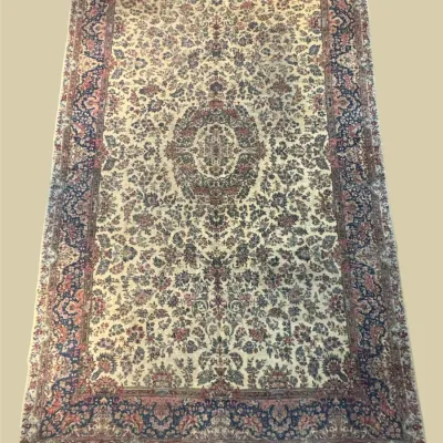 Blue and ivory traditional rug featuring a detailed central medallion surrounded by an intricate all-over floral pattern.