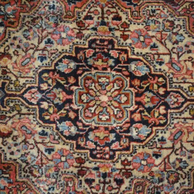 Blue, ivory, rust, and muted red traditional rug featuring a dense floral medallion pattern with intricate decorative detailing.