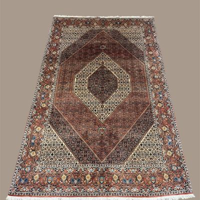 Soft mauve, ivory, burgundy, and muted blue traditional rug featuring layered diamond-shaped medallions and an intricate decorative border.