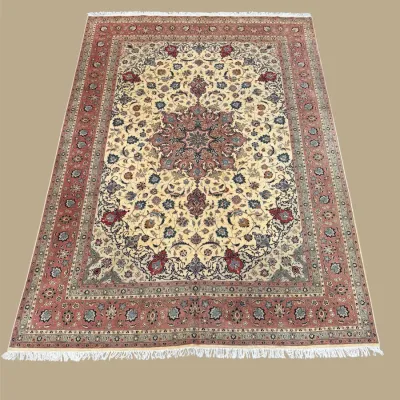 Rich red, ivory, and gold traditional rug featuring an elaborate central medallion, intricate floral detailing, and multiple decorative...