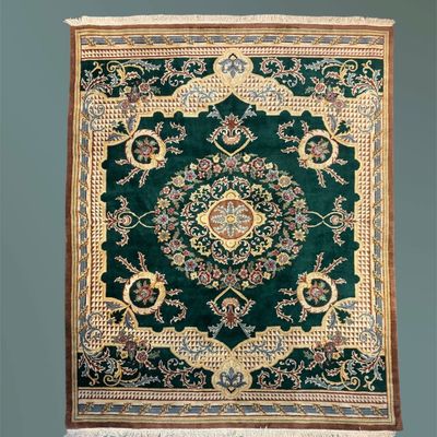 Deep green and ivory traditional rug featuring a prominent floral medallion, scrolling botanical motifs, and an elegant decorative border.