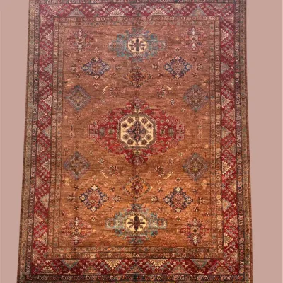 Warm rust and muted red traditional rug featuring a subtle all-over medallion design with gently distressed coloration.