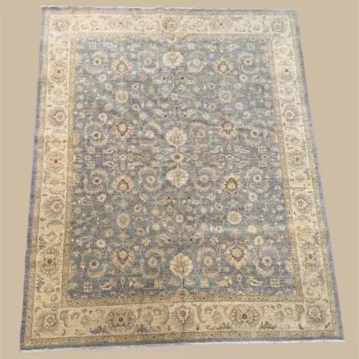 Soft blue and ivory traditional area rug featuring delicate floral detailing, an ornate central design, and a coordinating decorative...
