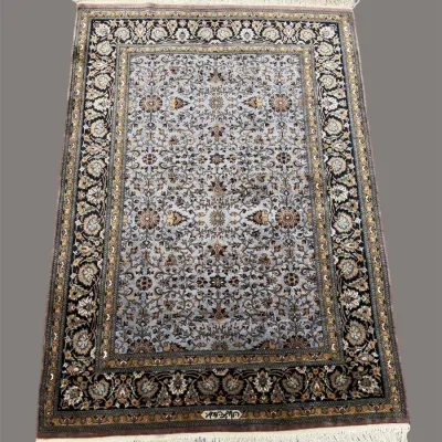 Dark blue, ivory, and gold traditional rug featuring an intricate all-over floral design with a highly detailed decorative border.