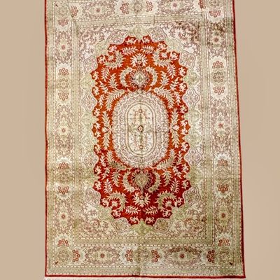 Soft ivory rug featuring a dramatic red central medallion with intricate floral detailing and subtle surrounding botanical motifs.