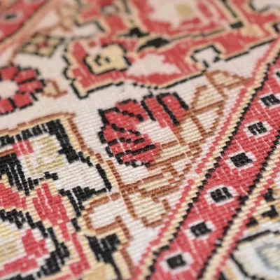 Detailed close-up showcasing intricate handwoven geometric patterns in red, ivory, black, blue, and warm accent colors.