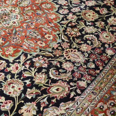 Dark floral rug featuring an elegant botanical pattern with ivory, red, green, and gold accents and an ornate decorative border.