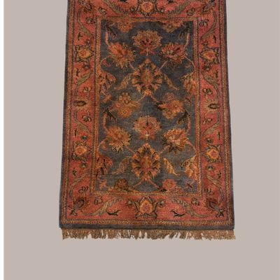 Warm rust and orange traditional rug featuring large floral motifs with muted green, blue, and gold accents and an ornate decorative border.