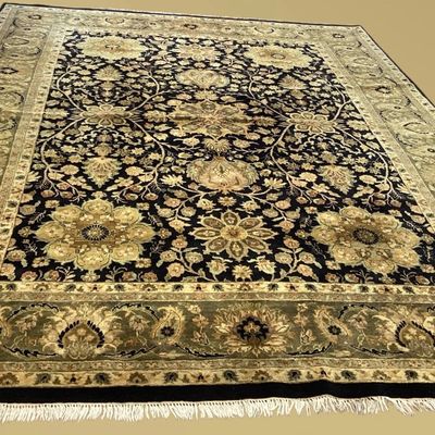 Black and gold floral rug featuring elegant traditional detailing, an ornate border, and finished fringe along the edge.