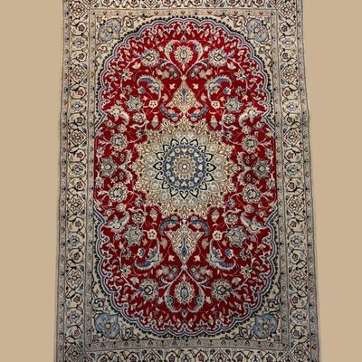 Burgundy, ivory, blue, and gold traditional rug featuring an elaborate oval medallion surrounded by dense floral detailing and an ornate...