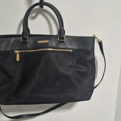 Sale Photo Thumbnail #15: This bag is the Michael Kors Colgate Large Tote Crossbody, a versatile piece crafted from durable black nylon with elegant Saffiano leather trim. [ NWOT]

Key Features Design: Features an East/West silhouette with a top zip closure.

Hardware: Accented wi