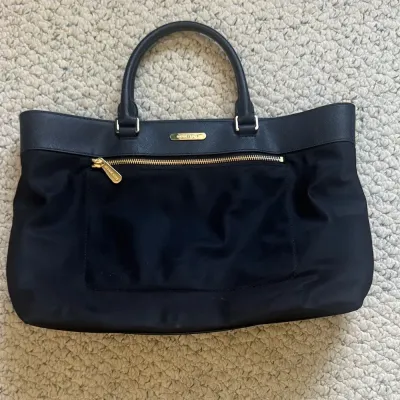 Sale Photo Thumbnail #16: This bag is the Michael Kors Colgate Large Tote Crossbody, a versatile piece crafted from durable black nylon with elegant Saffiano leather trim. [ NWOT]

Key Features Design: Features an East/West silhouette with a top zip closure.

Hardware: Accented wi