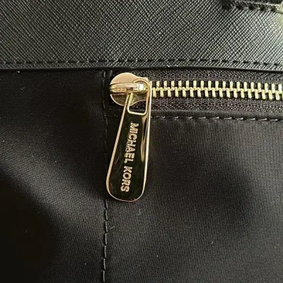 Sale Photo Thumbnail #22: This bag is the Michael Kors Colgate Large Tote Crossbody, a versatile piece crafted from durable black nylon with elegant Saffiano leather trim. [ NWOT]

Key Features Design: Features an East/West silhouette with a top zip closure.

Hardware: Accented wi