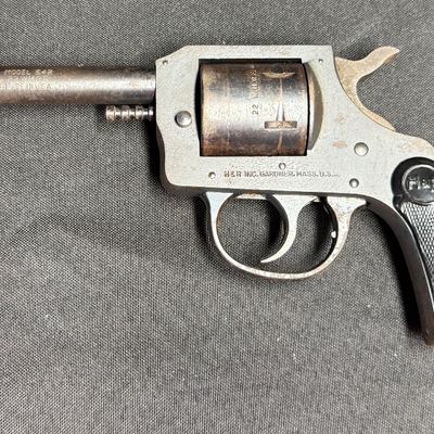 Sale Photo Thumbnail #419: This is a vintage six-shot double action rimfire revolver. It is chambered for .22 Winchester magnum rimfire. It has a four-inch barrel, and hard plastic grips. It has a parkerized frame with blued cylinder and barrel. These revolvers were produced betwee