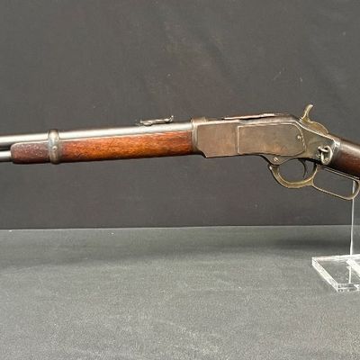 Sale Photo Thumbnail #446: This beautiful lever-action carbine is widely known as “The Gun That Won the West.” It features a 20-inch barrel, and holds 15 rounds of ammunition. It fires .44 Winchester Center Fire (.44-40) caliber ammo, a revolutionary round that could be used in