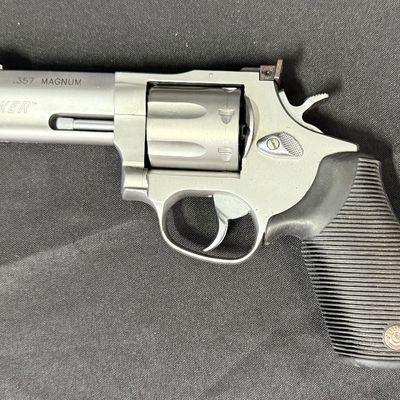 Sale Photo Thumbnail #410: This is a very nice matte stainless steel seven-shot, double action revolver. It fires .357 mag or .38 special (+P) ammo. It has a four-inch barrel, and soft rubber grips. It has a fixed front ramp and adjustable rear sight. It has a ported barrel to redu