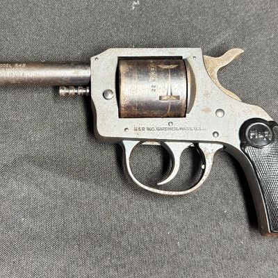 Sale Photo Thumbnail #418: This is a vintage six-shot double action rimfire revolver. It is chambered for .22 Winchester magnum rimfire. It has a four-inch barrel, and hard plastic grips. It has a parkerized frame with blued cylinder and barrel. These revolvers were produced betwee