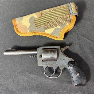 Sale Photo Thumbnail #416: This is a vintage six-shot double action rimfire revolver. It is chambered for .22 Winchester magnum rimfire. It has a four-inch barrel, and hard plastic grips. It has a parkerized frame with blued cylinder and barrel. These revolvers were produced betwee