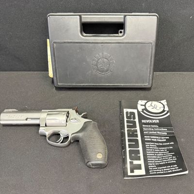 Sale Photo Thumbnail #409: This is a very nice matte stainless steel seven-shot, double action revolver. It fires .357 mag or .38 special (+P) ammo. It has a four-inch barrel, and soft rubber grips. It has a fixed front ramp and adjustable rear sight. It has a ported barrel to redu