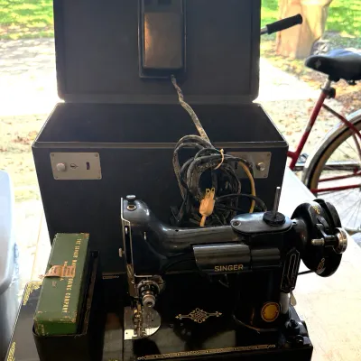 Vintage Black Singer Featherweight 221 portable electric sewing machine ft. gold scrollwork.
-Ft. green singer accessory box and black...