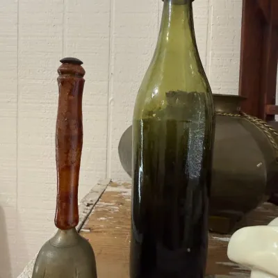 Antique olive green glass beer bottle and stone bell