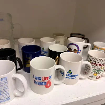 Assorted advertising coffee mugs and glass stein