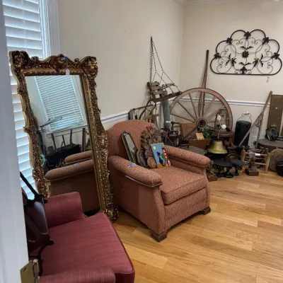 Ornate gilt floor mirror and upholstered armchair
