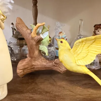 Yellow bird figurine on ceramic branch