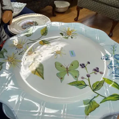 Scalloped ceramic chargers with butterfly and daisy motif