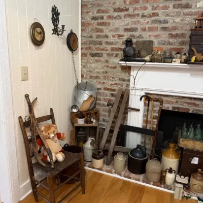 Primitive ladderback chair with stoneware jugs and antique ladder