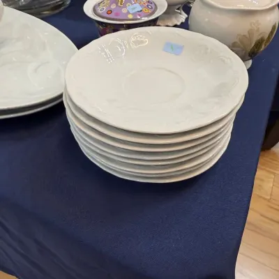 Stack of white embossed porcelain saucers