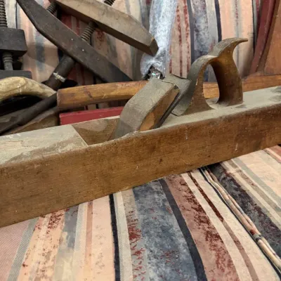 Antique wooden jointer plane and bar clamps