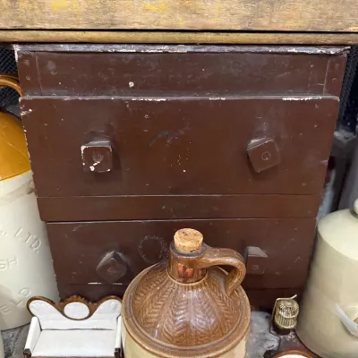 Antique metal trunk with stoneware whiskey jug