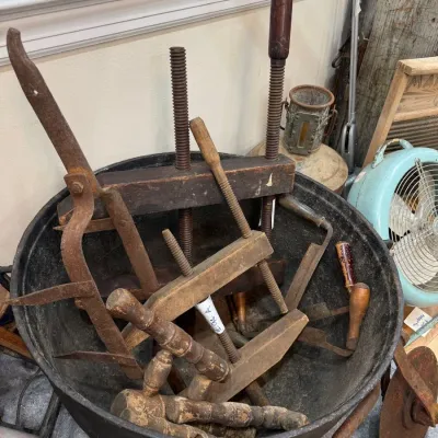 Cast iron cauldron of antique wood clamps and tools
