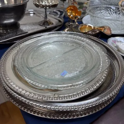 Stack of silverplate round trays and divided glass dish