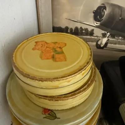Stack of vintage decorated tin canister lids