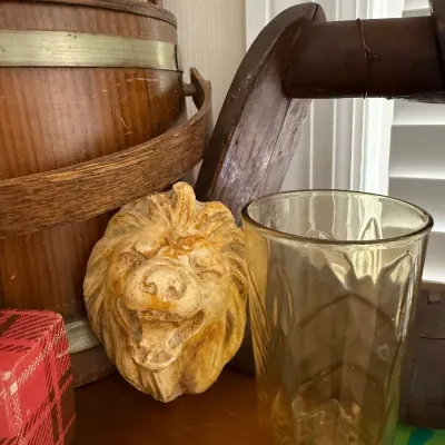 Carved lion head corbel and amber glass tumbler