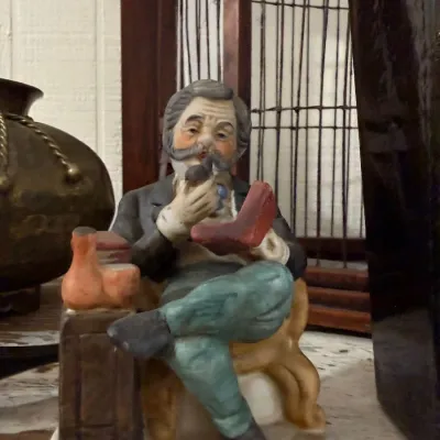 Porcelain figurine of seated pipe smoker