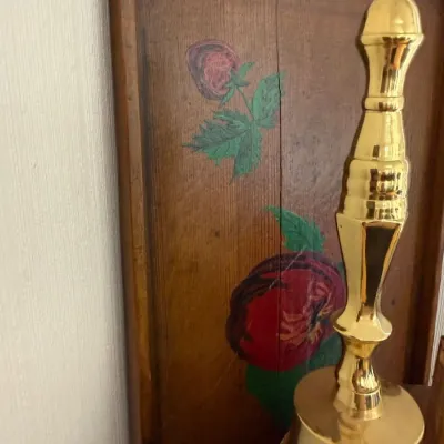 Brass bell and folk art painted rose wood panel