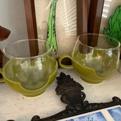 Pair of green glass cups with holders