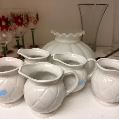 White ceramic pitchers and milk glass lamp shade
