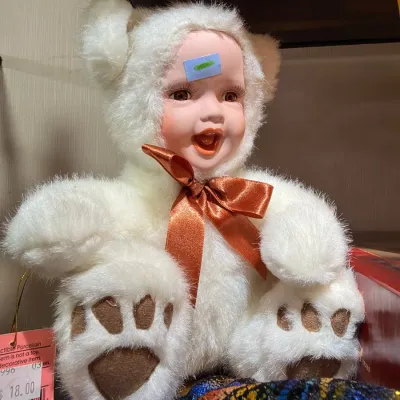 Porcelain baby doll in white bear costume